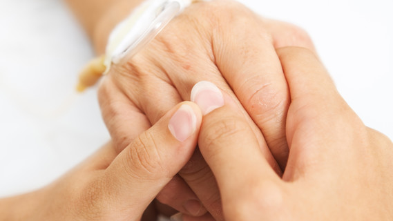 Tochter hält die Hand ihrer Mutter