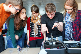 Mitarbeiter erklärt Studierenden eine Appartur