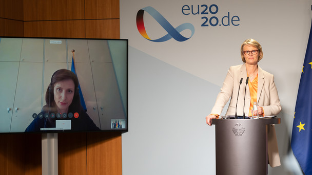 Bundesforschungsministerin Karliczek steht an einem Rednerpult. Während der Pressekonferenz ist EU-Forschungskommissarin Gabriel auf einem Bildschirm zugeschaltet.