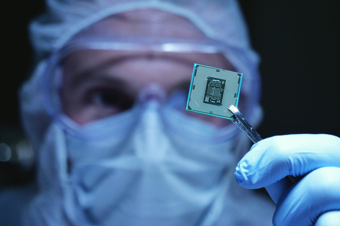 Konstruktionsingenieur im sterilen Overall hält Mikrochip