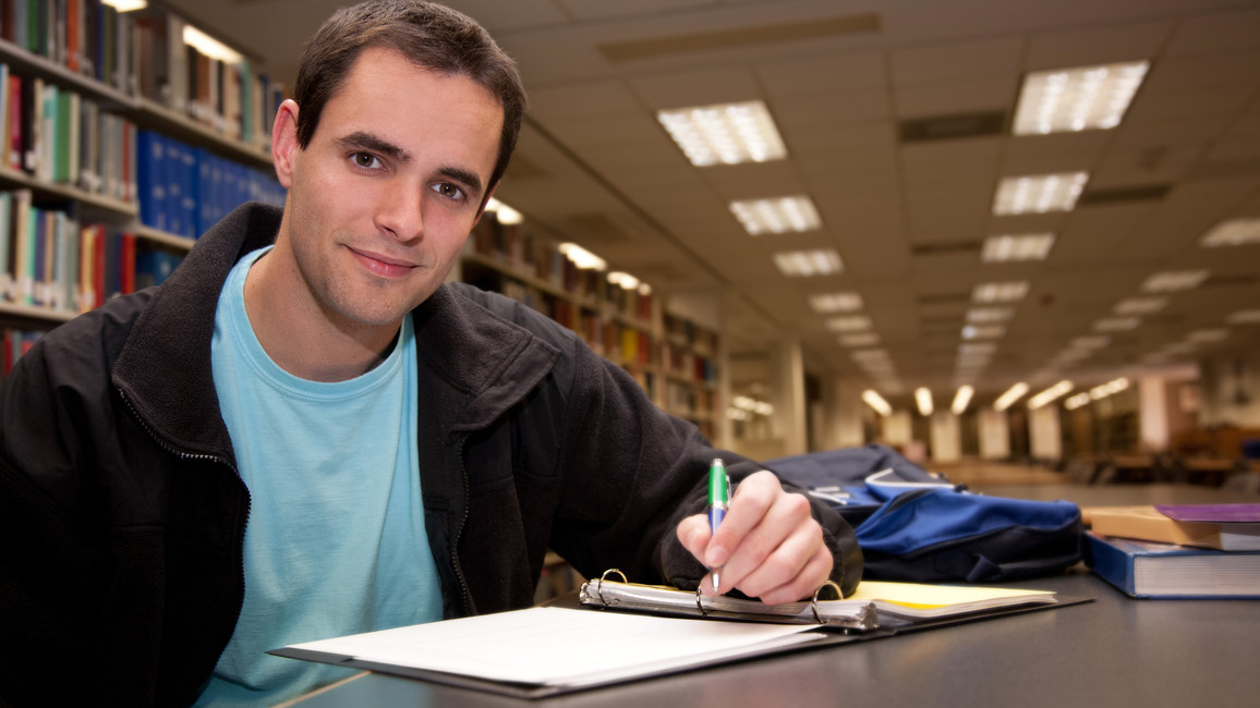 Junger Mann in einer Bibliothek