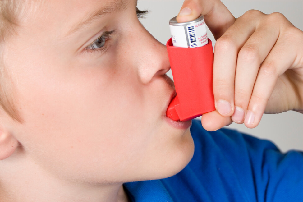 Kind inhaliert aus einem Dosierspray