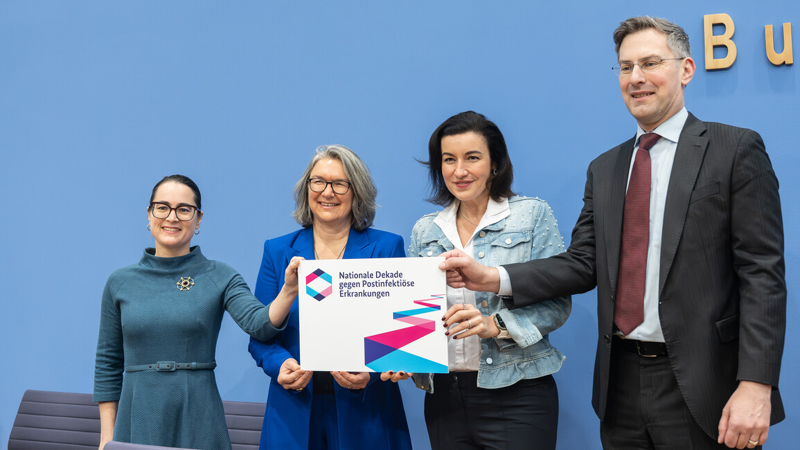Ministerin hält das Logo der NDPK hoch